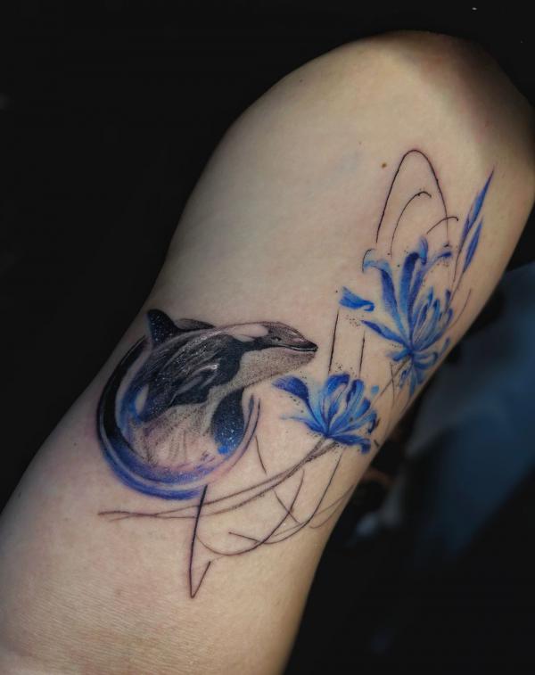 Dolphin and spider lily tattoo