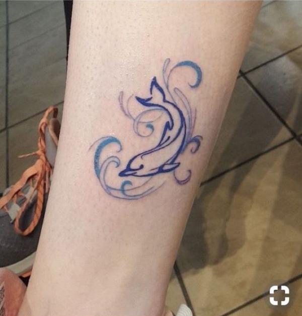 Dolphin and wave line work tattoo