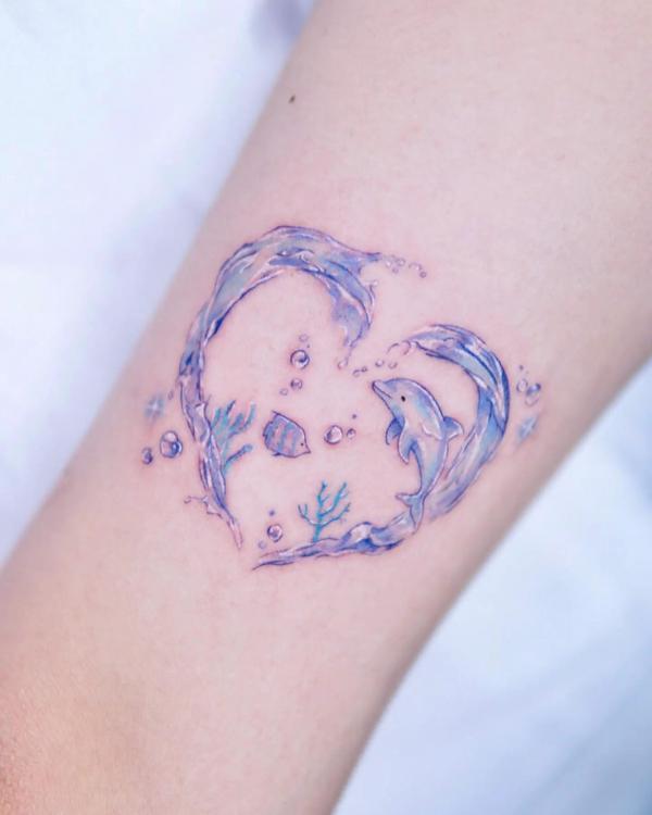 Dolphin in wave heart tattoo