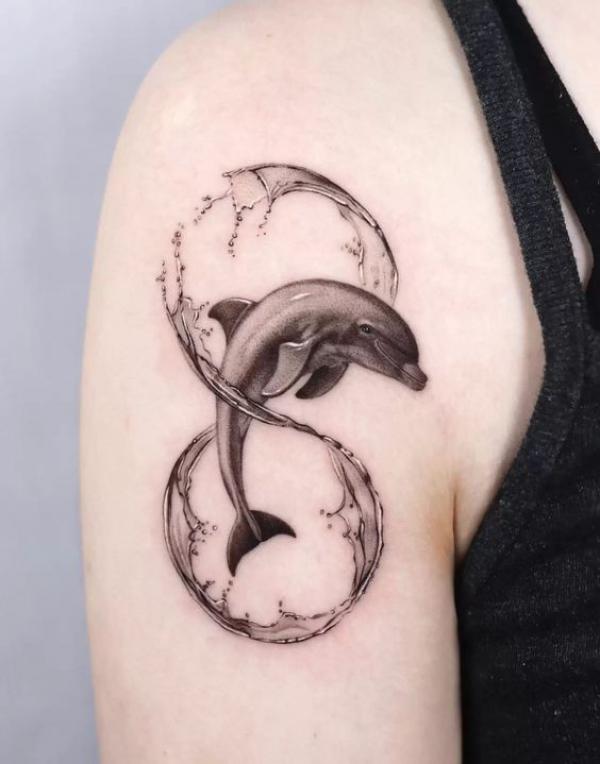 Dolphin jumping through infinity wave tattoo