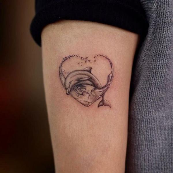 Dolphin jumping through wave heart tattoo