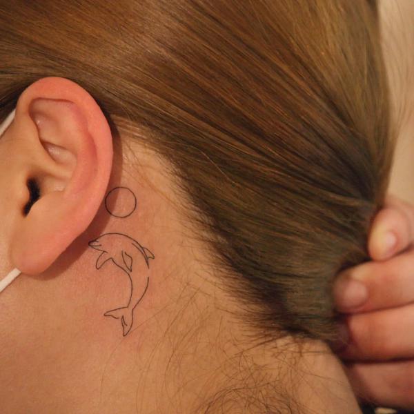 Dolphin outline tattoo behind ear