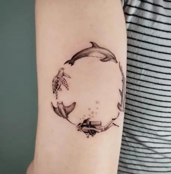 Dolphin sea turtle ray scuba diver hammerhead shark swimming in circle tattoo