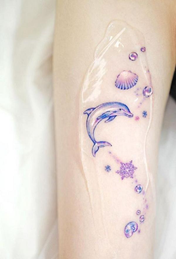 Dolphin with shell and stars tattoo feminline style