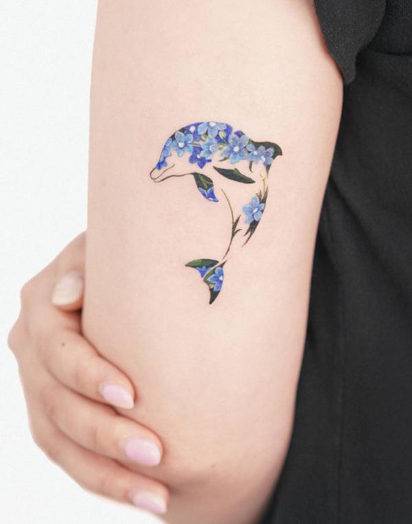 Floral dolphin back of arm tattoo