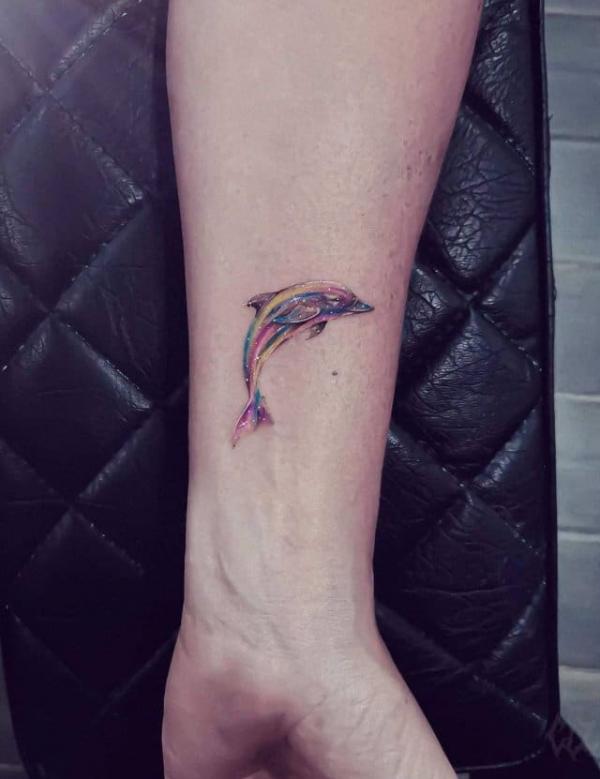 Galaxy dolphin tattoo on forearm