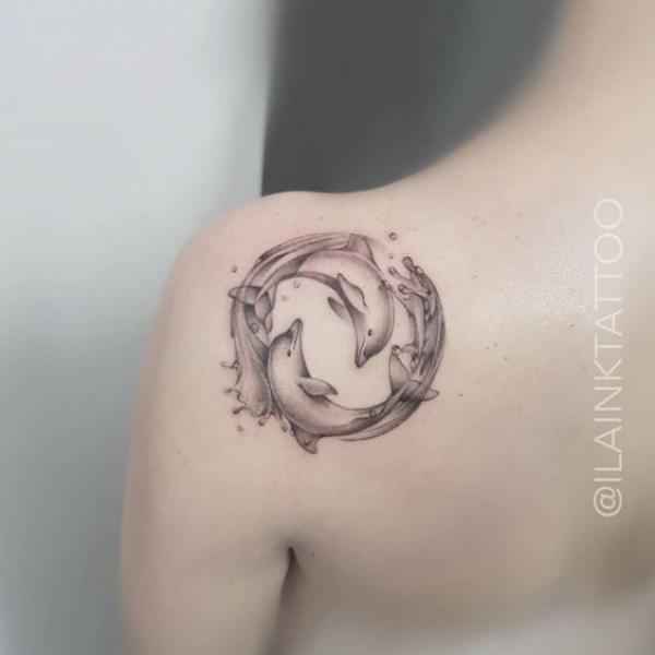 Greyscale two dolphin in circle shoulder blade tattoo