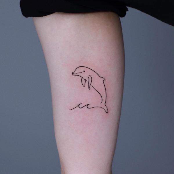 Simple Dolphin and wave tattoo on inner forearm