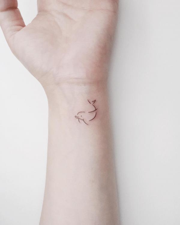 Simple dolphin outline wrist tattoo