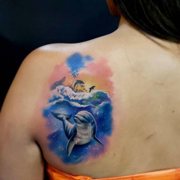 Swimming dolphin shoulder blade tattoo