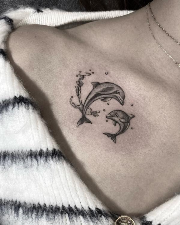 Two dolphin clavicle tattoo