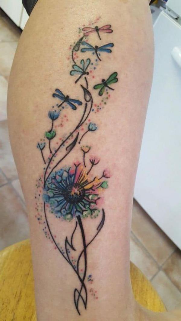 Minimalistic dandelion seed tattoo placed behind the