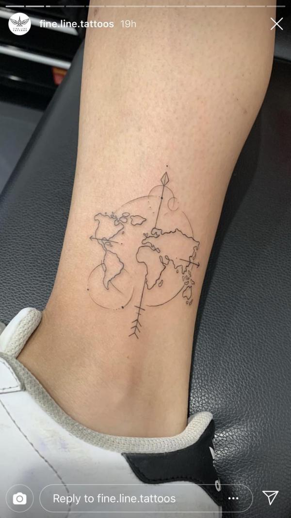 Dainty globe map tattoo above ankle