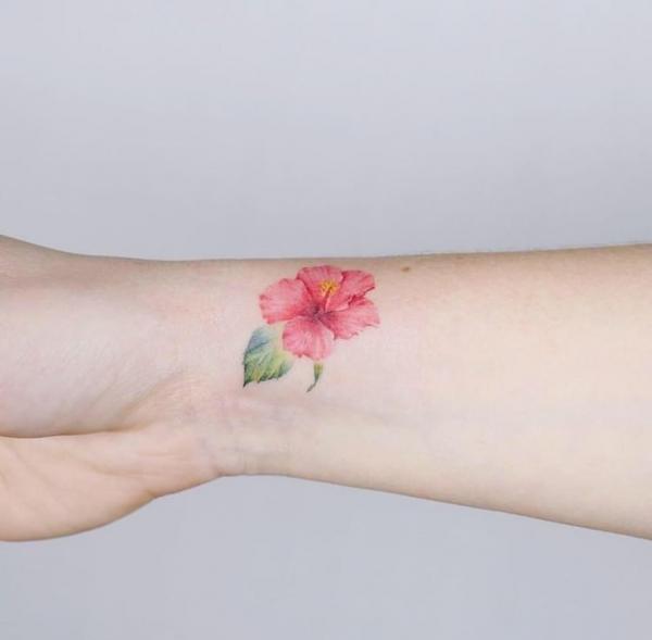 Dainty small hibiscus tattoo on wrist