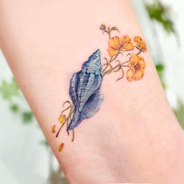 Conch shell and yellow flower tattoo