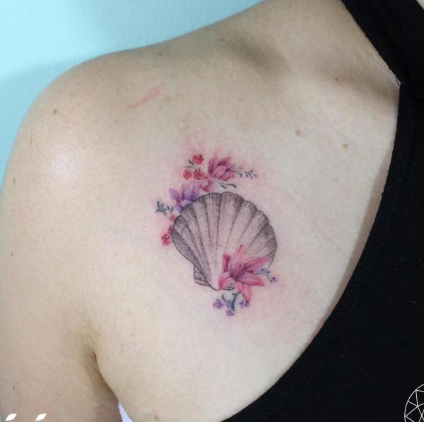 Cute shell with colored flowers above boob tattoo
