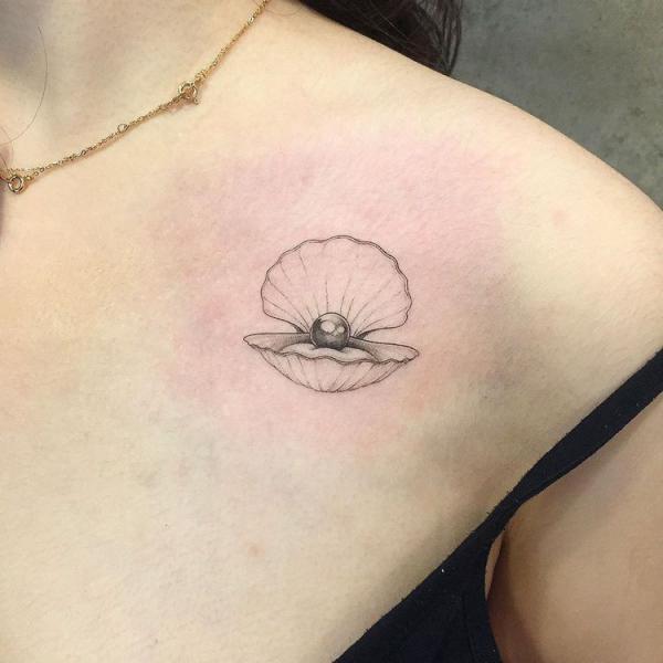 Dainty pearl in shell clavicle tattoo