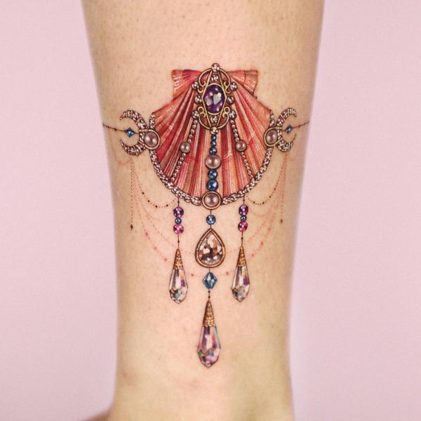 Feminine shell with jewelry pendant tattoo