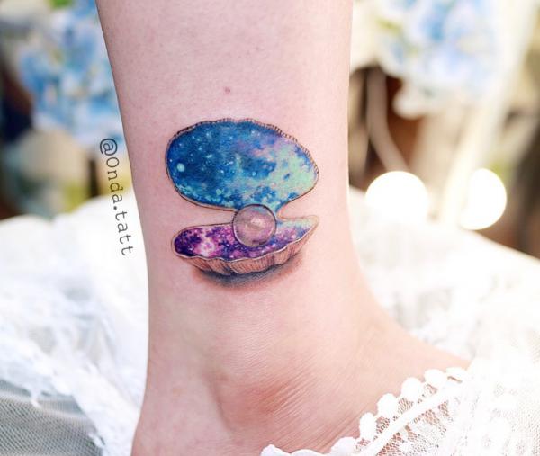 Galaxy and pearl in shell tattoo