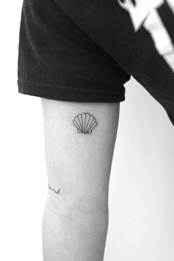 Minimalist shell bicep tattoo
