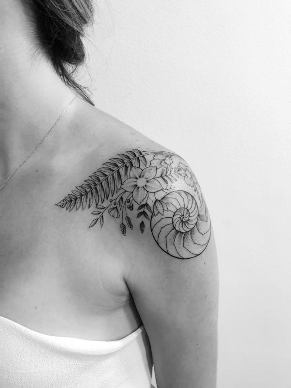 Nautilus shell with fern shoulder tattoo black and grey