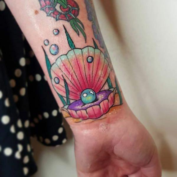 Pearl in shell wrist tattoo colorful