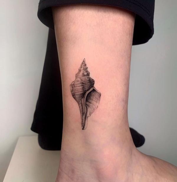 Realistic conch shell tattoo above ankle