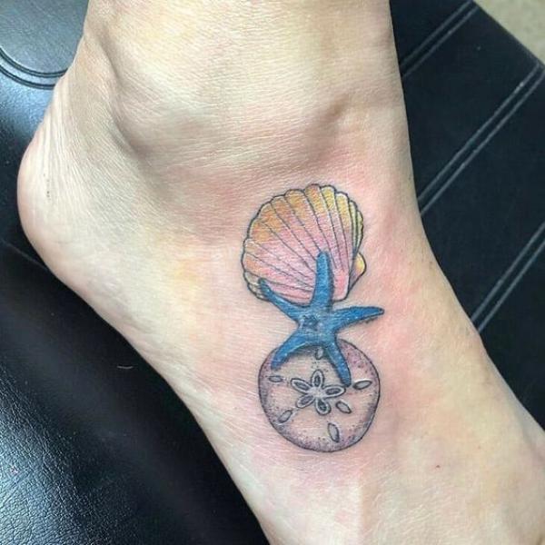 Scallop shell and sand dollar with starfish tattoo on foot