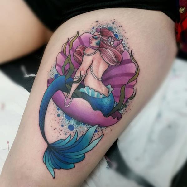 Shell and mermaid tattoo on thigh
