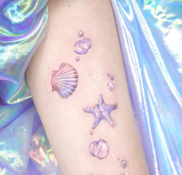 Shell and starfish with pearls arm tattoo