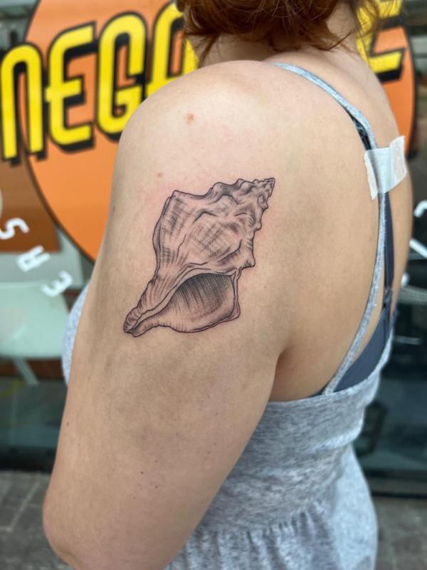 Shell back of arm tattoo
