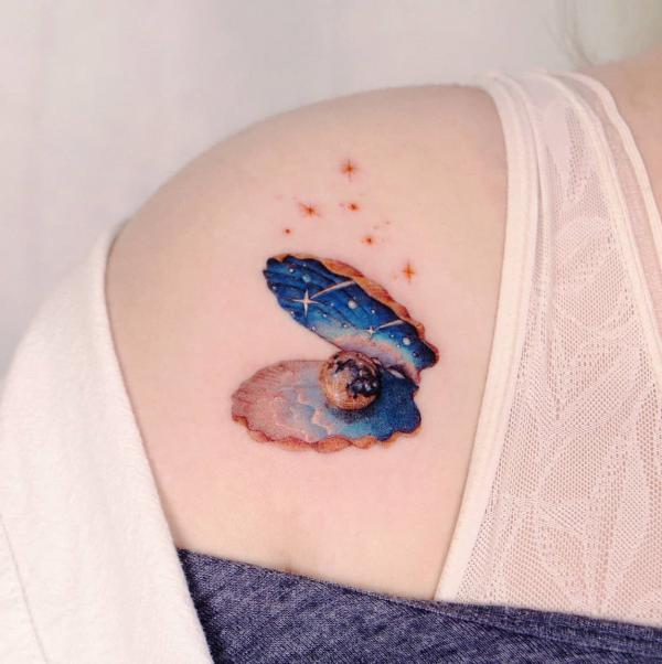 Starry night and planet in shell clavicle tattoo