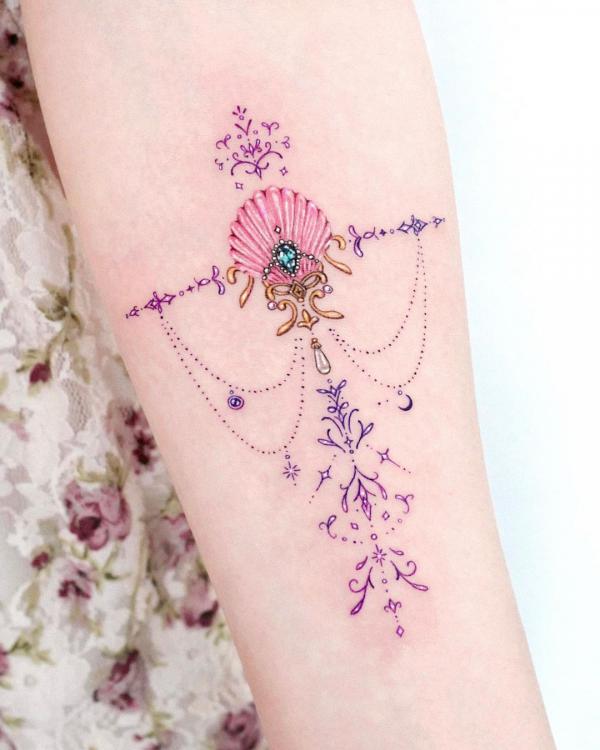 Stylish feminine shell with pendant tattoo