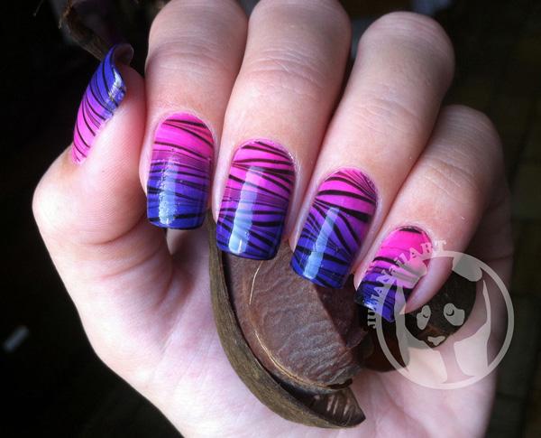 A zigzag patterned water marble nail art design in black polish over a pink and blue gradient base color.