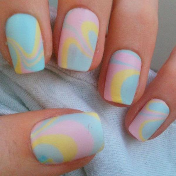 Water marble nail art design in baby pink, yellow and blue colors.