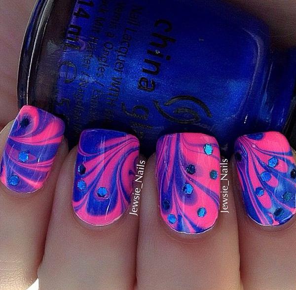 Simply make flower patterns using blue and pink polishes in water marble nail art design and add blue beads on top for effect.