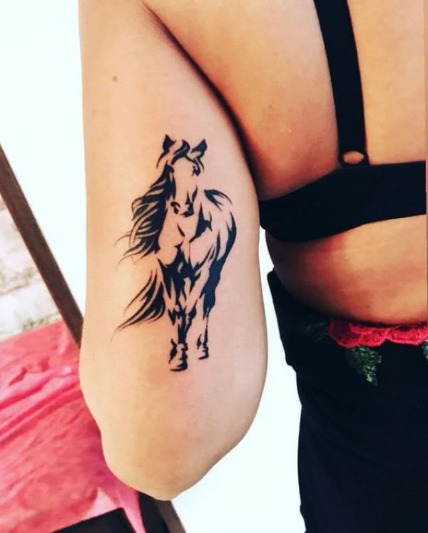 Black and white horse back of arm tattoo