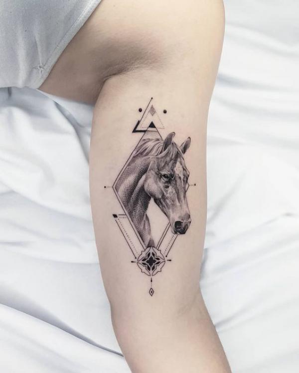 Geometric horse head bicep tattoo
