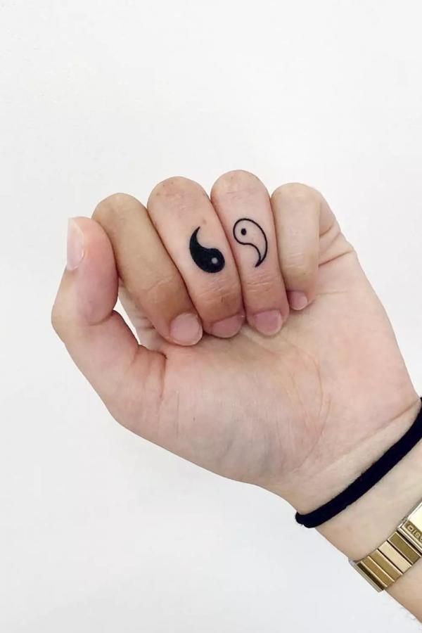 Simple yin yang finger tattoo