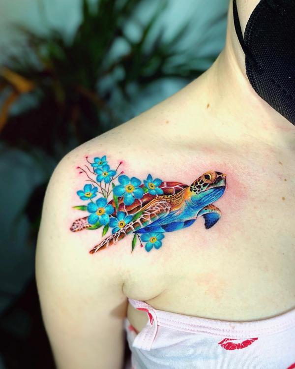 Female turtle with flower clavicle tattoo