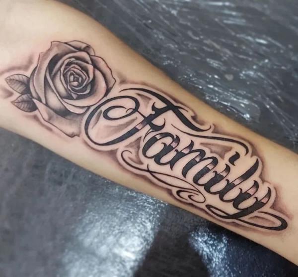 Family font and rose forearm tattoo
