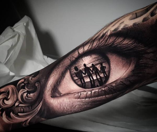 Family reflection in realistic eye tattoo on bicep