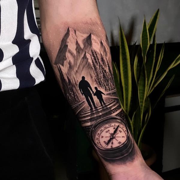 Father holding sun with compass and mountain tattoo