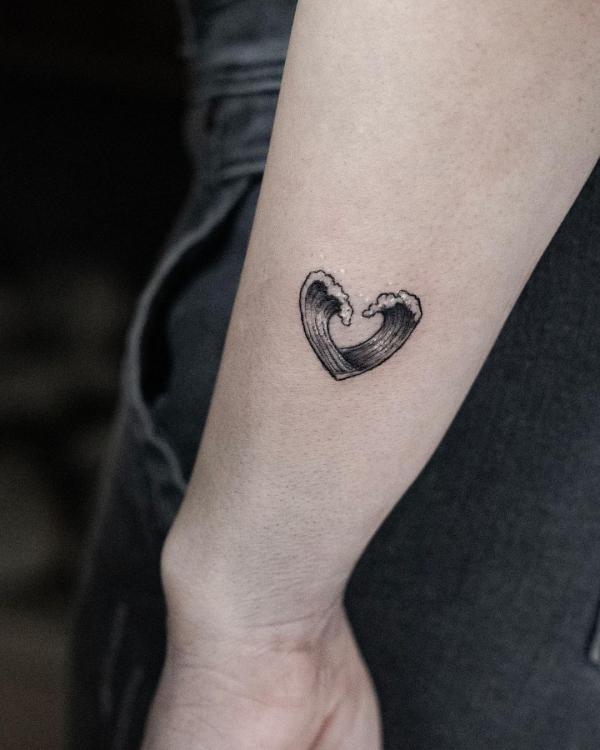Small wave tattoo in hear shape on arm