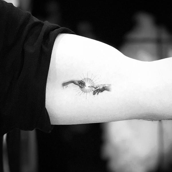 A miniature tattoo inspired by the hands in The Creation of Adam