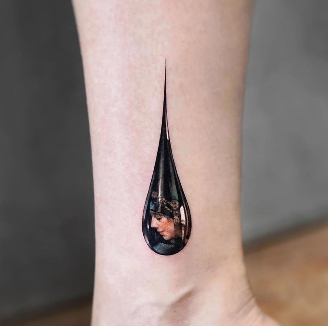 Minimalist teardrop tattoo with a portrait inside