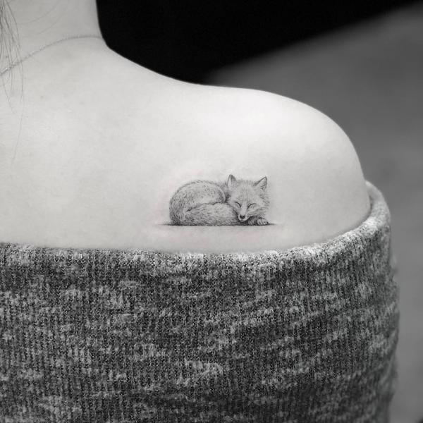 miniature tattoo of a Sleeping little fox on shoulder