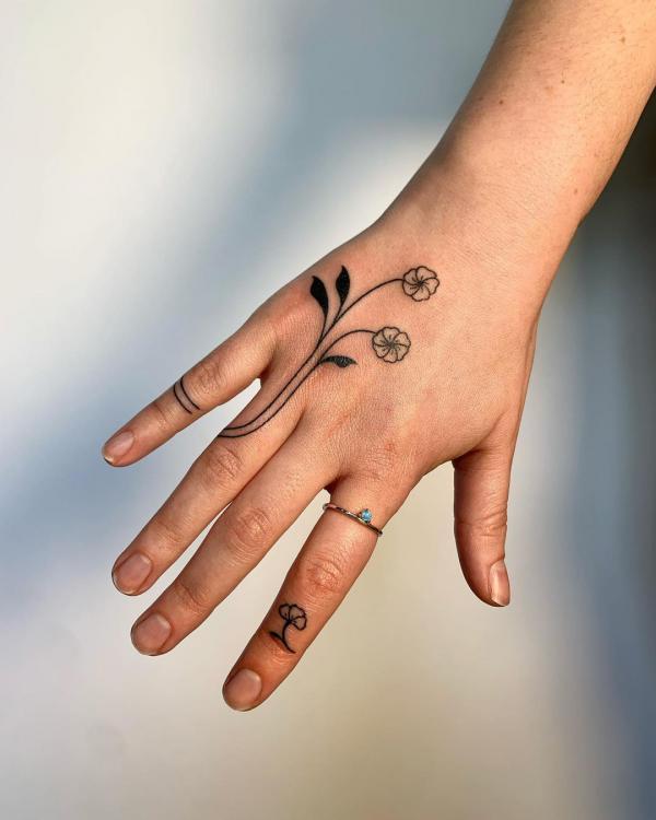 Minimalist daisy tattoo on the fingers