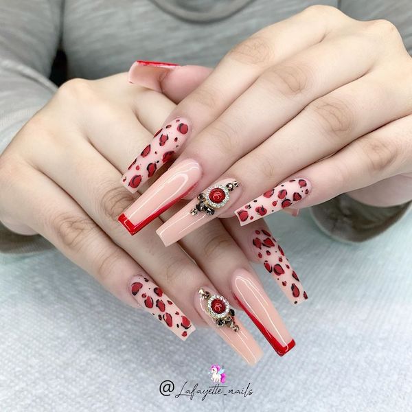 Black and scarlet leopard patterns in coffin shapes adorn the pink nail beds