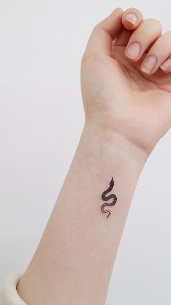 A tattoo of a writhing serpent on the wrist